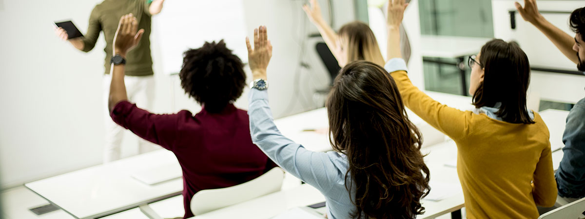 Personas levantando sus manos en un aula