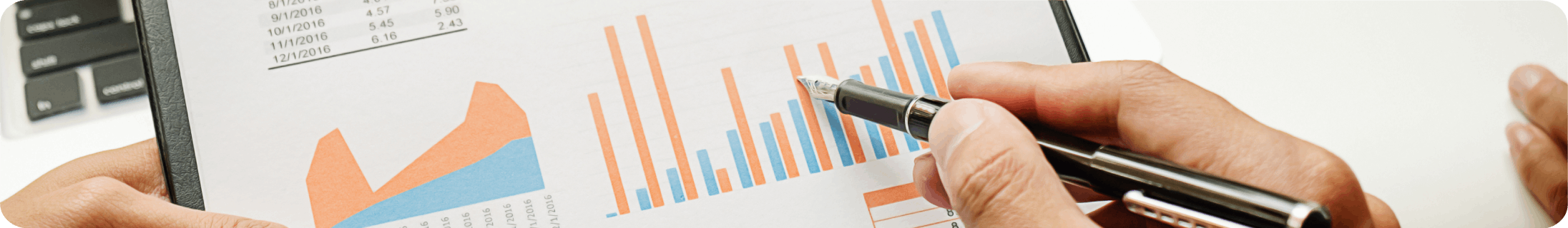 Mano señala con un bolígrafo gráficos de barras y áreas en un informe